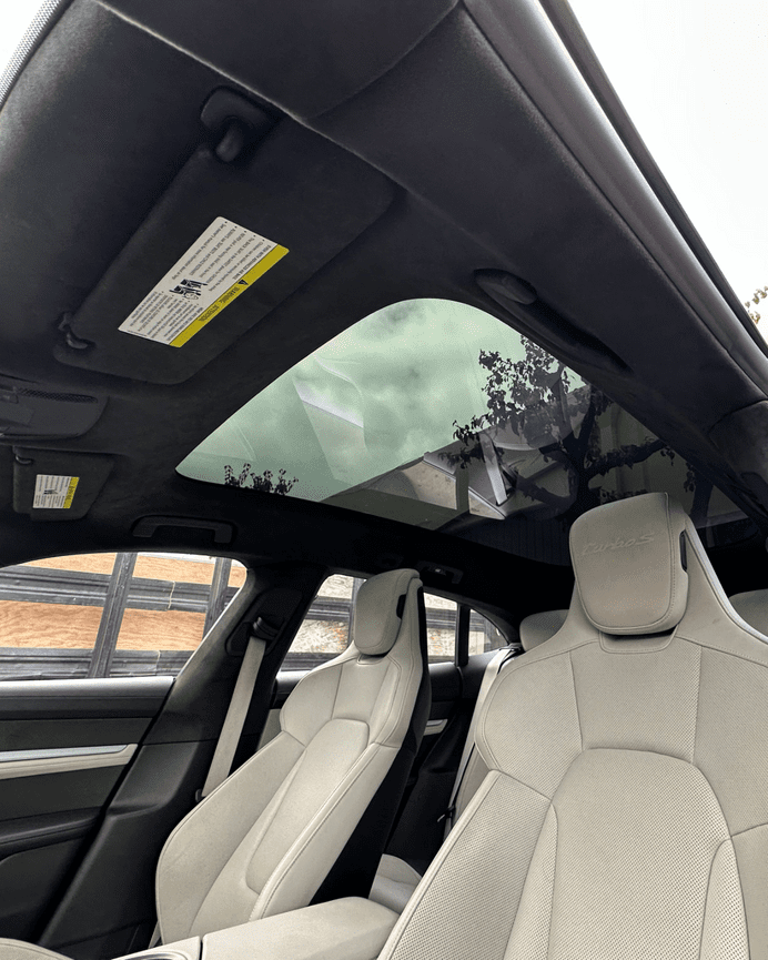 Interior view of Porsche Taycan glass roof panel above front seats after replacement