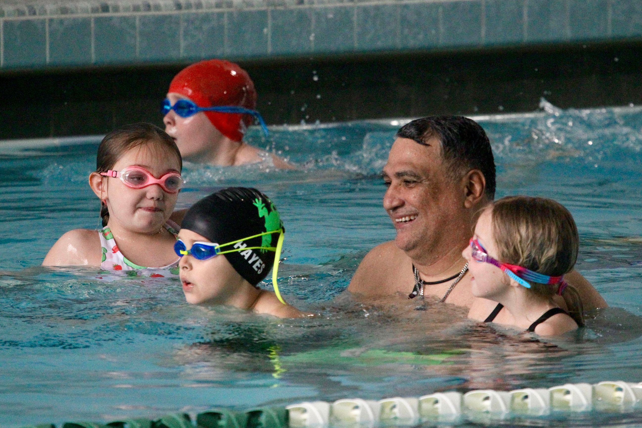 Photo of Manager/Coach Ed Gomez with Friendly swimmers at Greensboro College